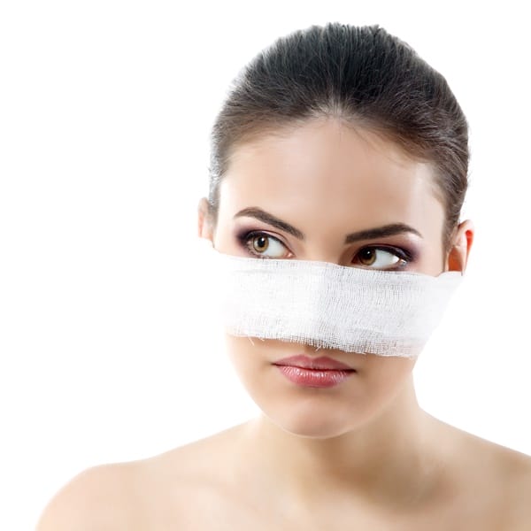 portrait of beautiful young female face with bandage on her nose